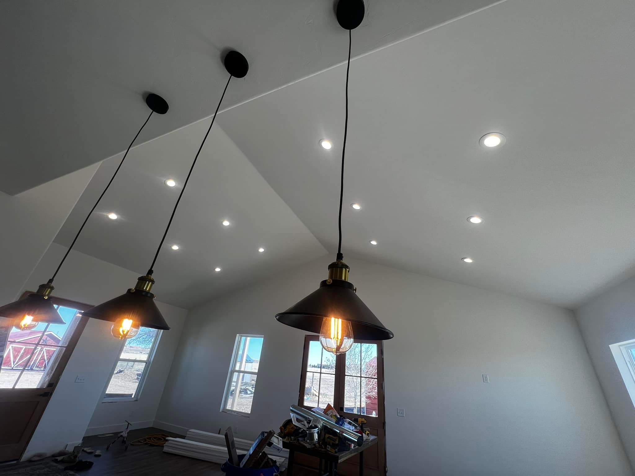 Island pendant lighting with a view of living room and dining room recessed lighting in a home addition in Fort Lupton, CO